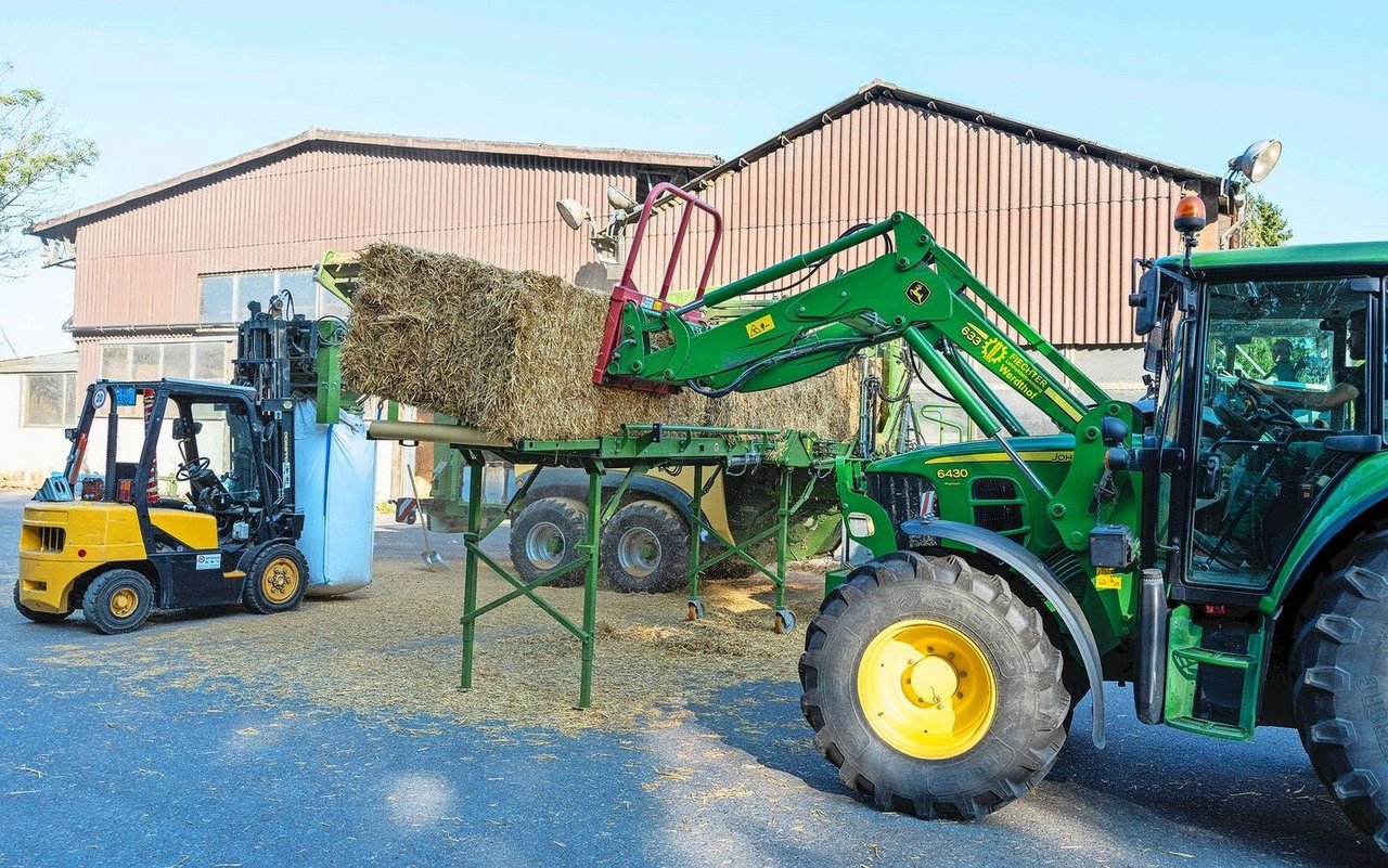 Für die stationäre Pelletherstellung kann ein Förderband für die Ballenzufuhr an die Presse angekoppelt werden. Dieses System funktioniert nur für Quaderballen. 