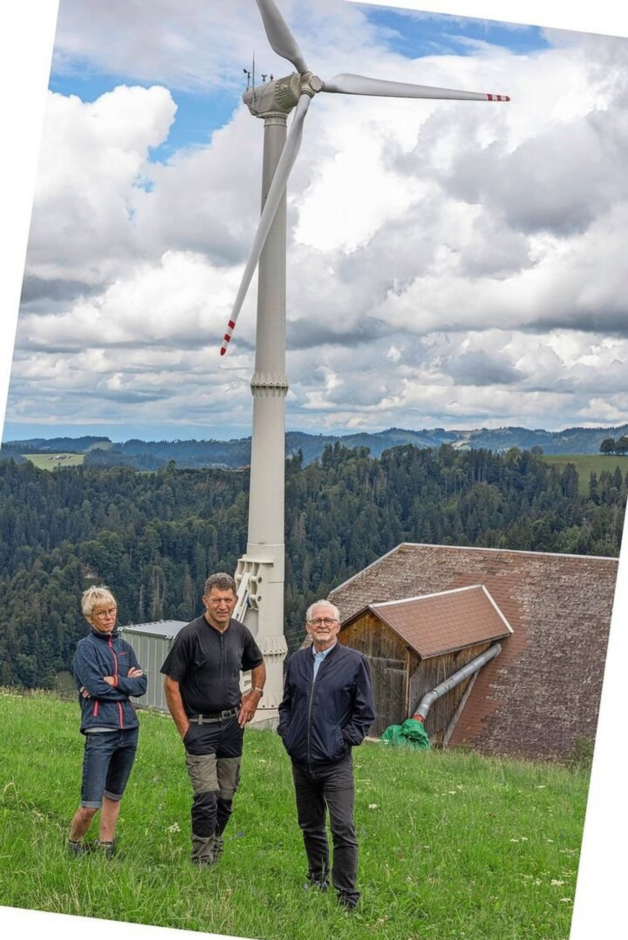 Rita und Bernhard Riedweg und Frido Stutz von New Green Tec vor der Kleinwindanlage neben dem Bergbetrieb von Familie Riedweg aus Escholzmatt.