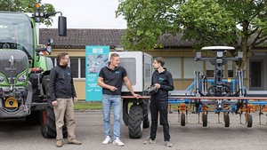 Swiss Future Farm Nils Zehner (AGCO) Roman Gambirasio (GVS)und Florian Abt (Arenenberg) stehen vor einem Fendt-Traktor sowie einem Feldroboter.