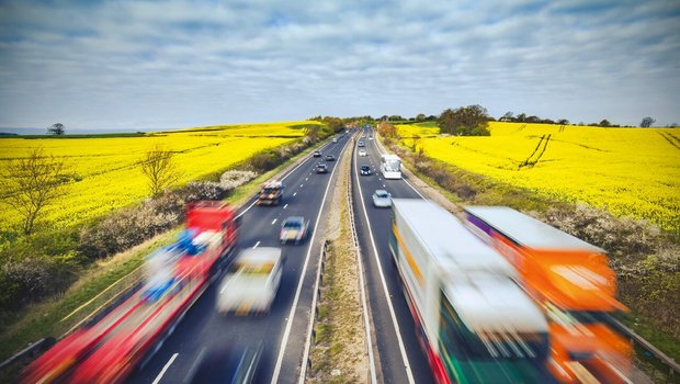 Strassenverkehr auf einer Autobahn mitten in Landwirtschafts-Land. Bild: Adobe